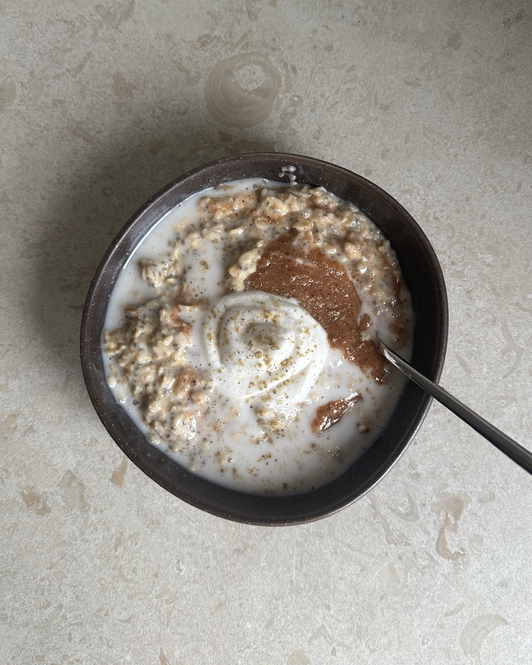 Skål med krämig semmelgröt toppad med kardemumma, kokosgrädde och hemmagjord sockerfri mandelmassa