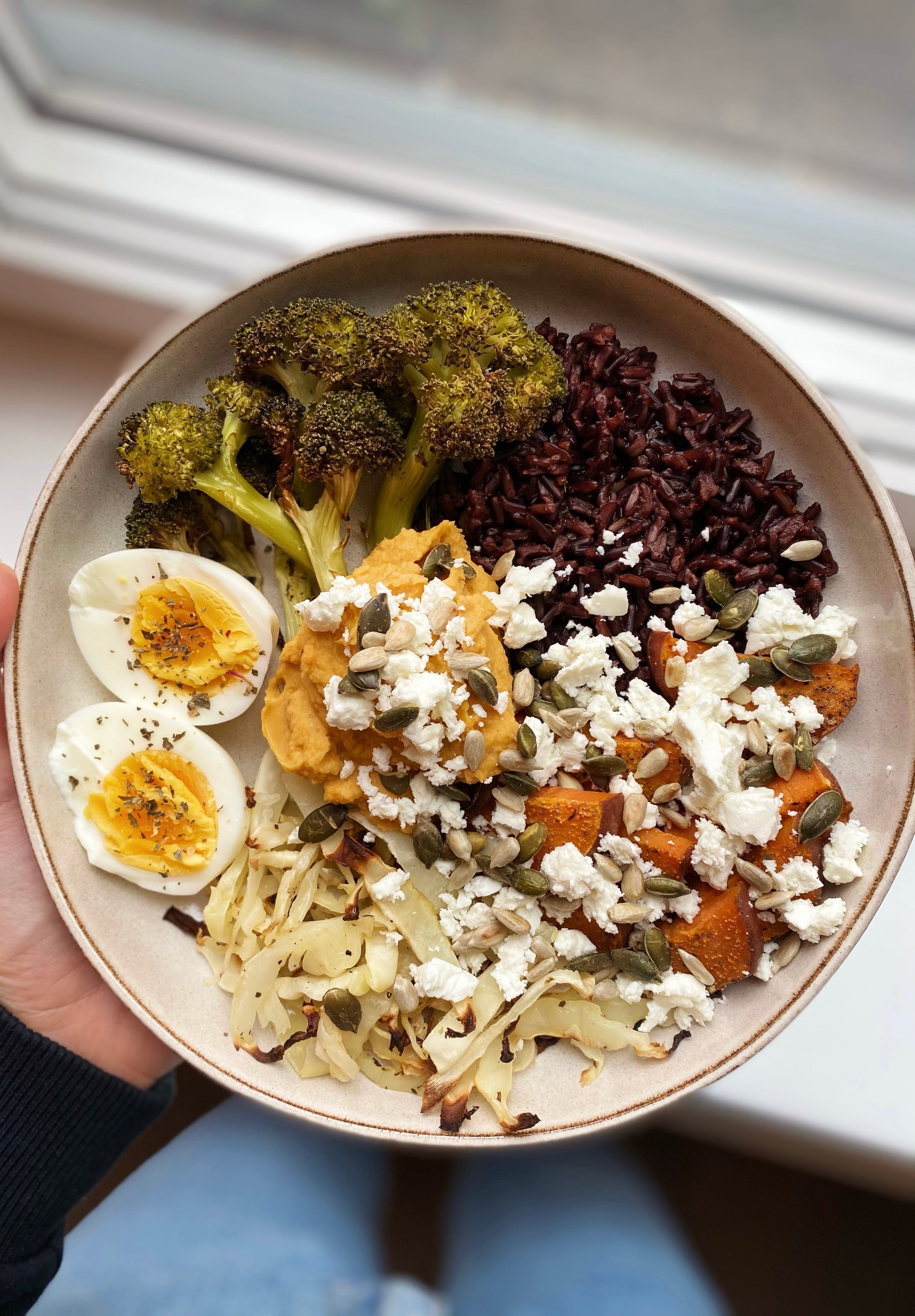 Sötpotatisbowl med svart ris, hummus, ugnsbakade grönsaker, fetaost och ägg - perfekt måltid för menscykel i balans
